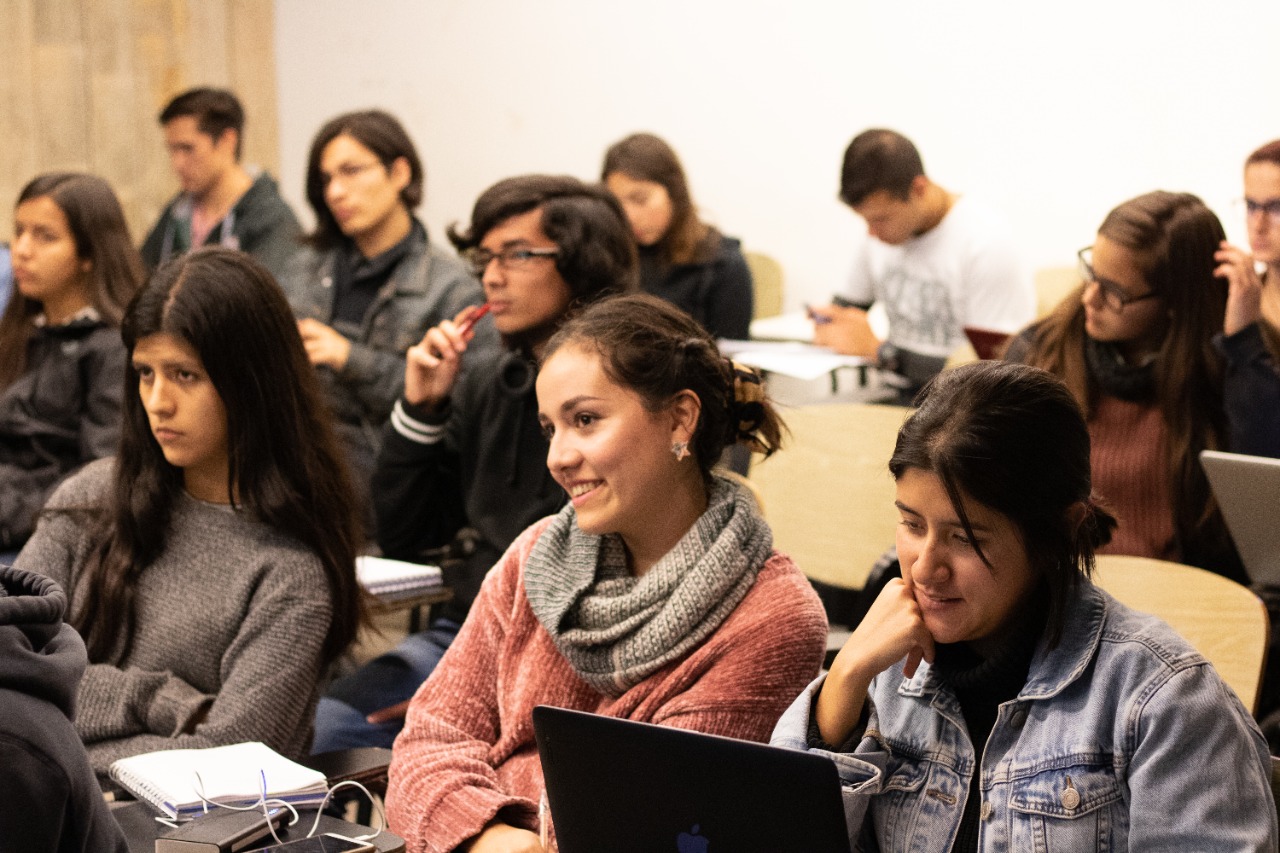 Estudiantes universitarios sentados en una sala de clases